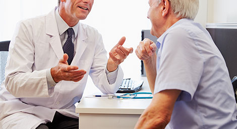 A doctor speaking with an older male patient